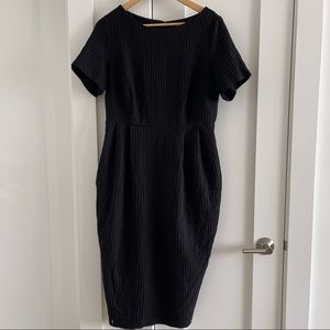 Black waffle-knit dress with pockets and tulip skirt